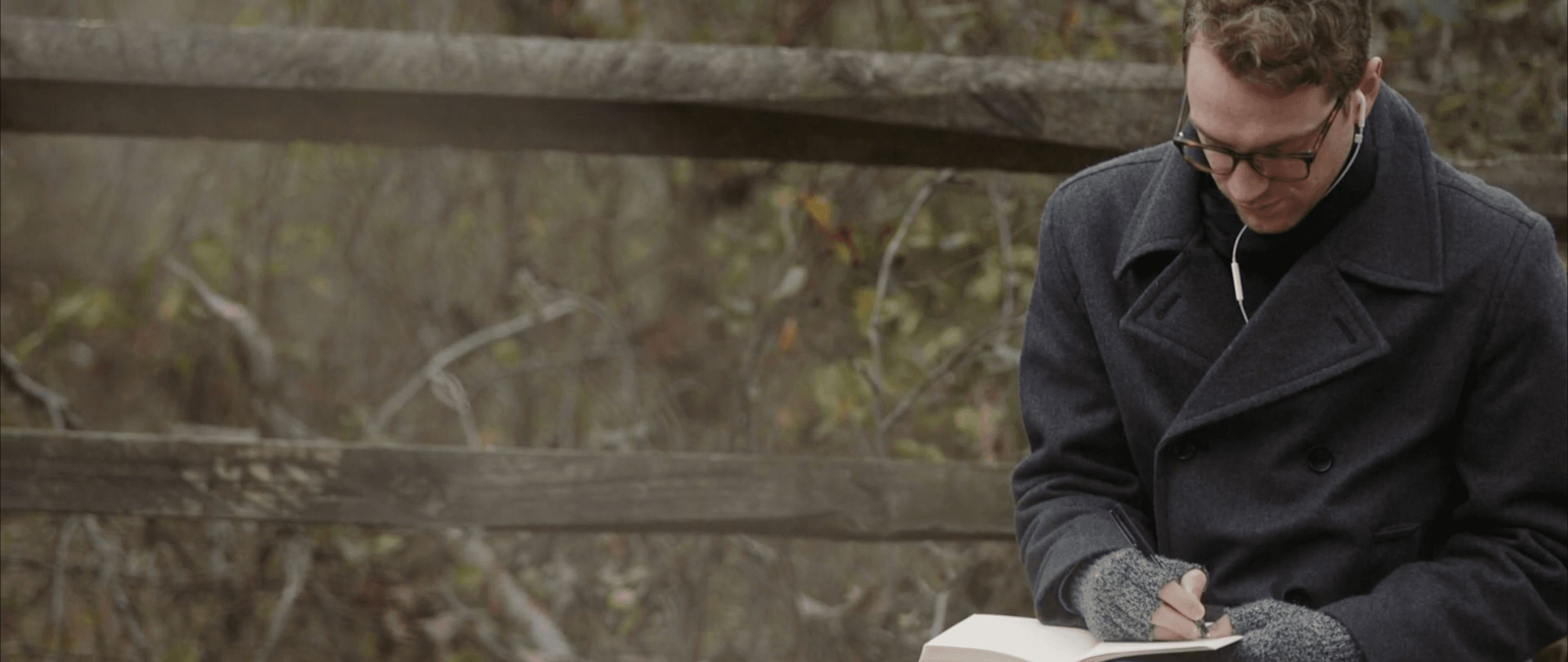 Jared Boggess drawing in his sketchbook at a battlefield
